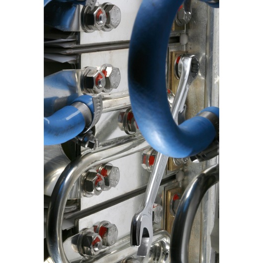 Facom 440_1_2 spanner on metal pipes with blue insulation, close-up industrial photography.