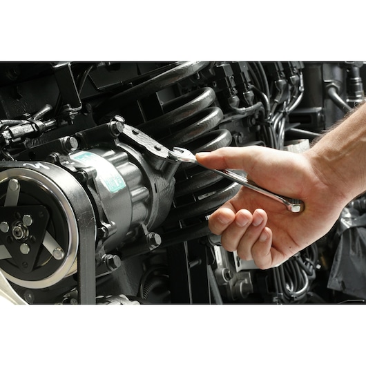 Facom 440.9/16 combination wrench used to tighten a bolt on a machine engine.
