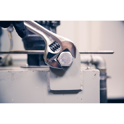 Photo of Facom adjustable wrench 101_12 tightening large bolt in industrial setting.