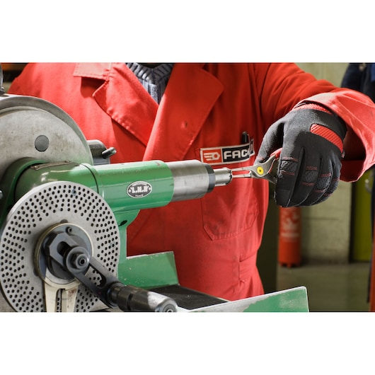 Facom 177A23 pliers held by gloved hand, working with green lathe machine in workshop setting.