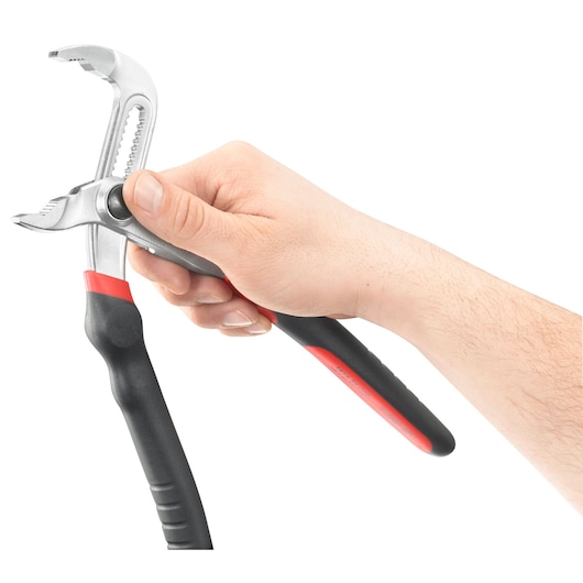 A hand holding an adjustable water pump pliers with a black and red handle, shown against a white background.