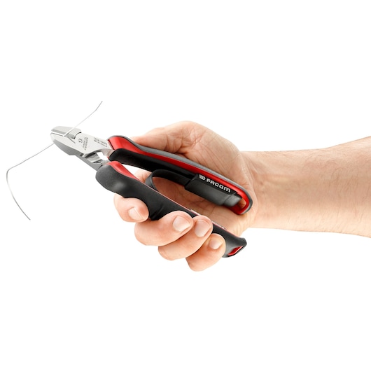 Photo of Facom 192A16CPE diagonal cutting pliers with black and red handle, shown in hand cutting wire.