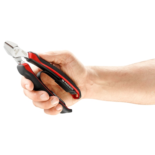 Facom 192A16CPE diagonal cutting pliers with black and red handle held in hand, side view.