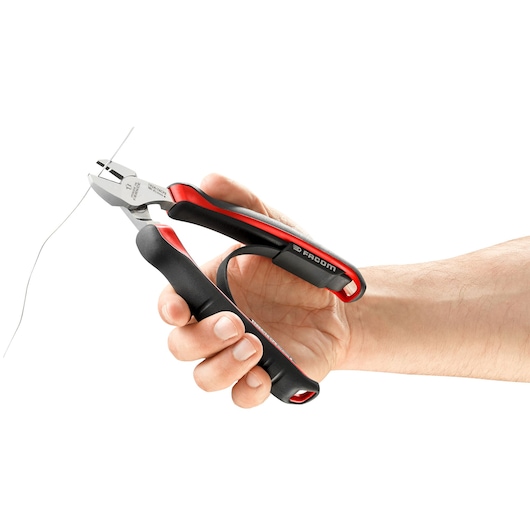 Photo of Facom 192A_18CPE side cutting pliers with black and red handles in use, cutting wire, close-up.
