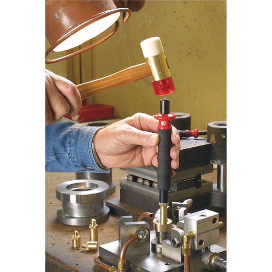 Facom 208A_60CBA punch tool with black and red handle in use on metal workbench, struck by mallet.