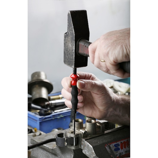 Facom 249_G12 screwdriver with black and red handle used in industrial setting, close-up photography.