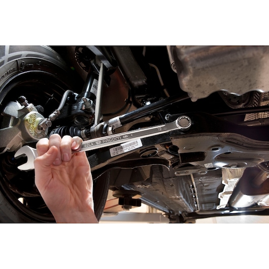 Facom 40_29LA combination wrench used for automotive repair under vehicle chassis.