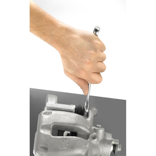 Photo of Facom 440_13 combination wrench in use tightening a metal automotive part from top angle.