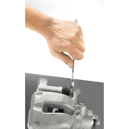 Facom 440_32 combination wrench used to tighten a bolt on a metal automotive part, close-up angle.