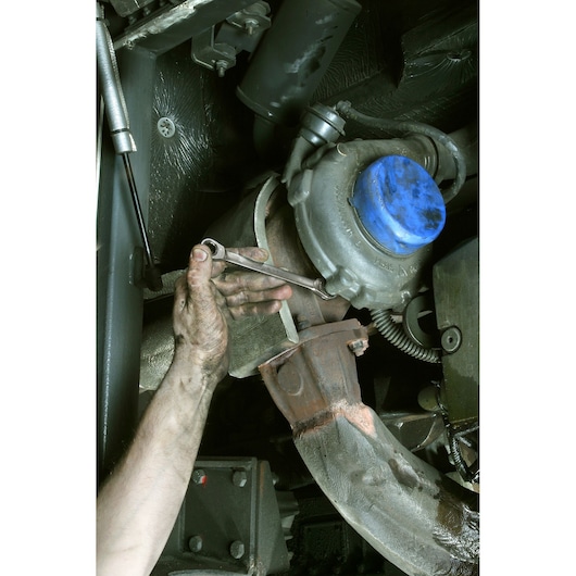 Photo of a mechanic using Facom 64_10X11 wrench on an engine undercarriage.