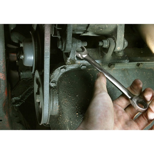 Facom 64_10X11 combination wrench used on a bolt during automotive repair, photo shows close-up hand action.