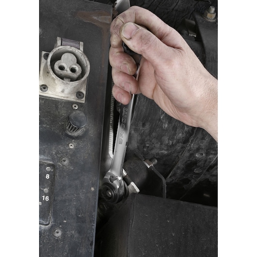 Facom 64C_J2PB ratcheting wrench used by a hand to tighten a bolt in a mechanical assembly.