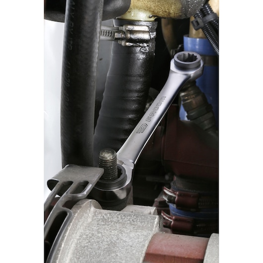 Facom 64C_S2 combination wrench on bolt in automotive engine, close-up photo.