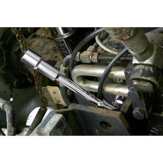Facom 75_24 chrome socket wrench in use on machinery part, close-up photography.