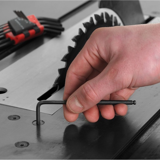 Facom hex key set 83SH_12 with ball end, close-up of hand using hex key on metal surface near saw blade.