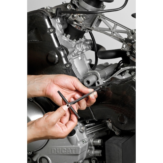 Photo of Facom 84TCD_5 T-handle hex key tool being used on a motorcycle engine, close-up view.