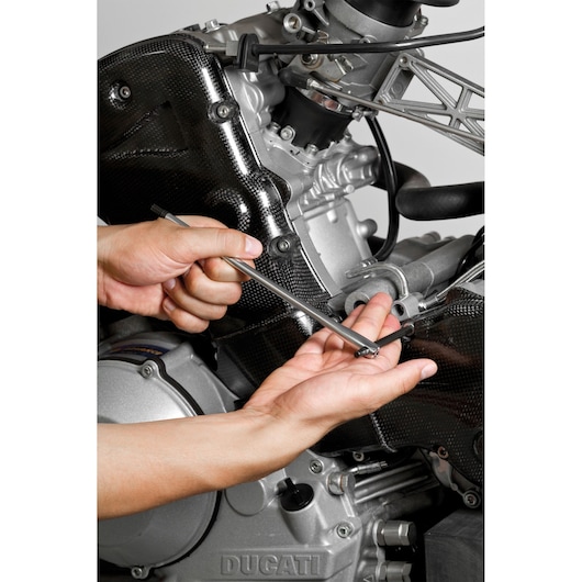 Facom 84TCD_5 hex key in use on motorcycle engine, close-up photography.