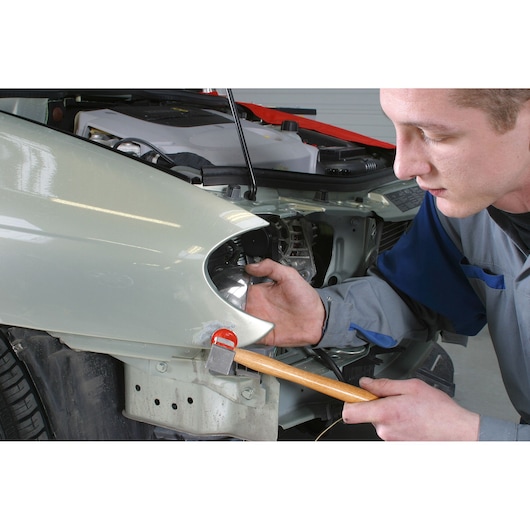 Facom 871B_45 hammer with wooden handle used for car bodywork repair near headlight.