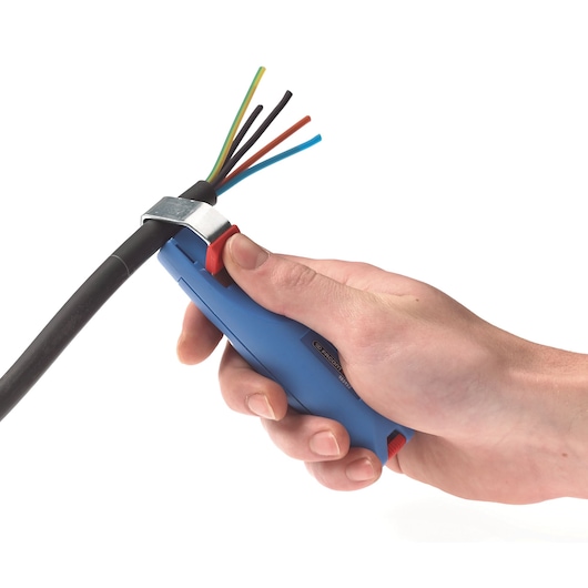 Facom 985952 wire stripper tool with blue handle in hand stripping black cable on white background.