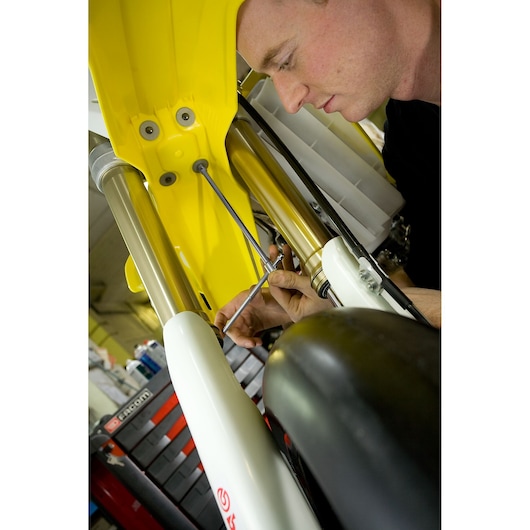 Facom 98B_14 photography of mechanic using tool on yellow and white motorcycle front fork.