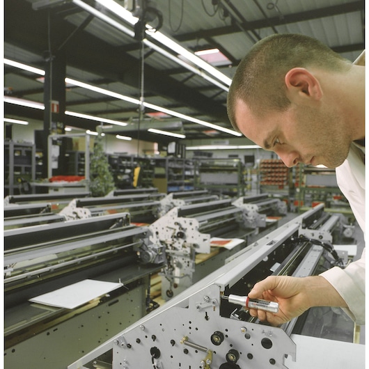 Facom A_341MT screwdriver used to assemble machinery in a factory, close-up of tool and hand.