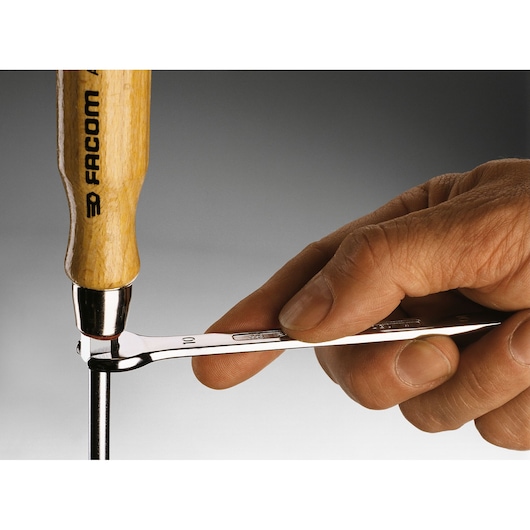 Facom ATHH_8X150 photography of hand using wrench and wooden handle tool on metal rod.