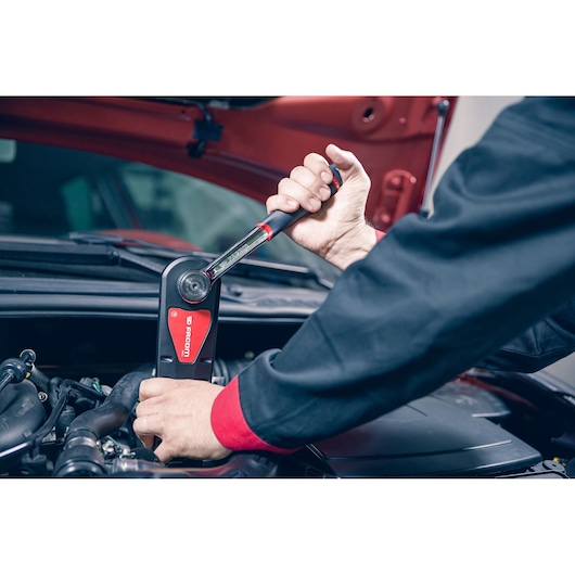 Facom torque wrench AXS.LPB used on car engine, close-up photography of tool in mechanic’s hand.