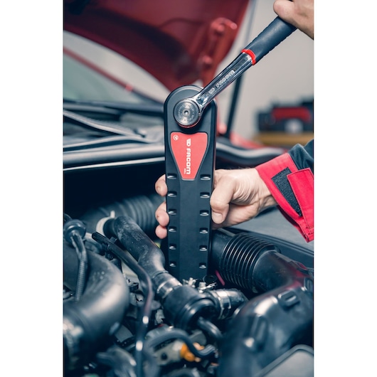 Photo of Facom AXS_M ratchet wrench in use on a car engine, black and red handle visible.
