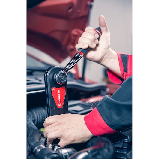 Photo of Facom AXS_M ratchet wrench used by mechanic on car engine.
