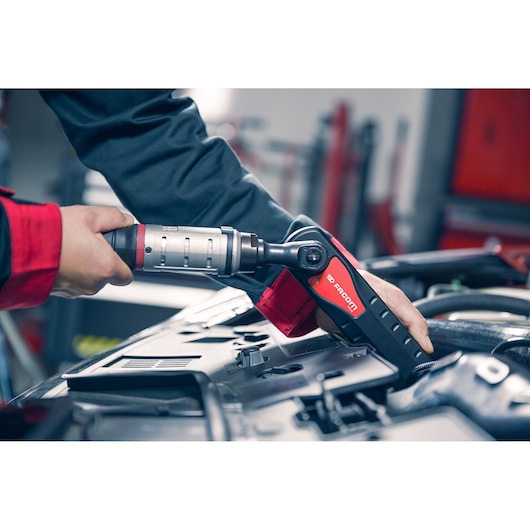 Photo of Facom cordless ratchet wrench AXS.SPB used on vehicle engine in workshop setting.