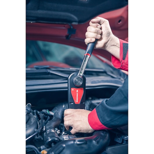 Facom AXS.SPB ratchet wrench used by mechanic on car engine, close-up photography.