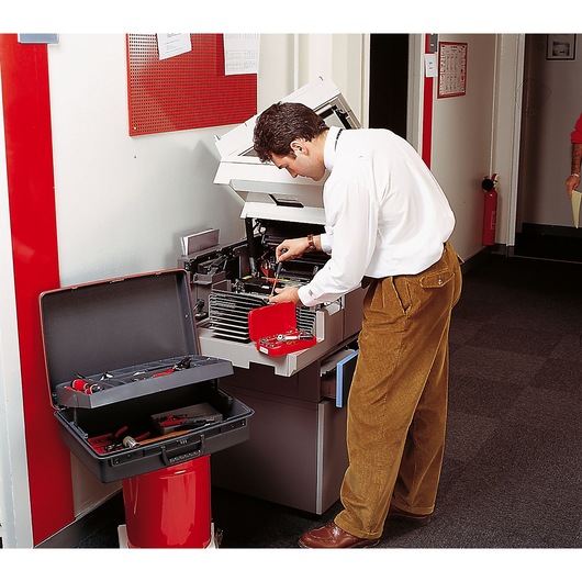 Facom BV_21ST photography of technician using tool kit to repair office copier.