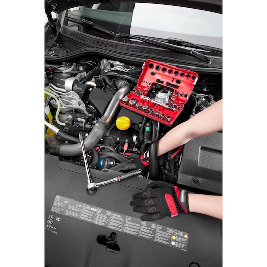 Facom C48-1 socket set with red case used for car engine maintenance, gloves visible, top view.