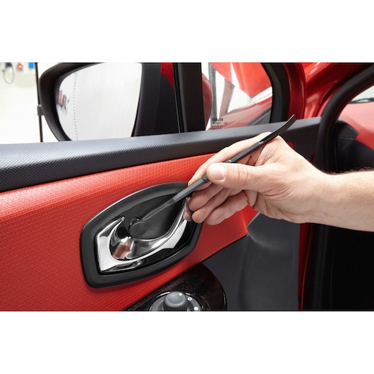 Photo of Facom CR.LPTPB trim removal tool being used on a car door handle, close-up view.
