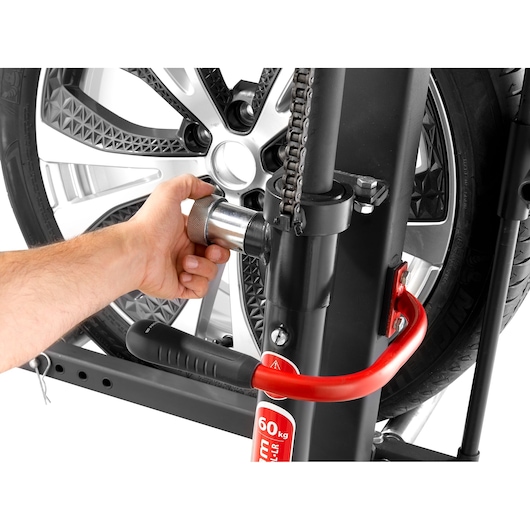 Facom DL_LR photography of a hand adjusting a metallic knob on a tire lifting tool, side angle.