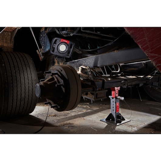 Facom DLPL22A photography of a heavy-duty vehicle axle with a Facom work light and a 22 ton jack stand.
