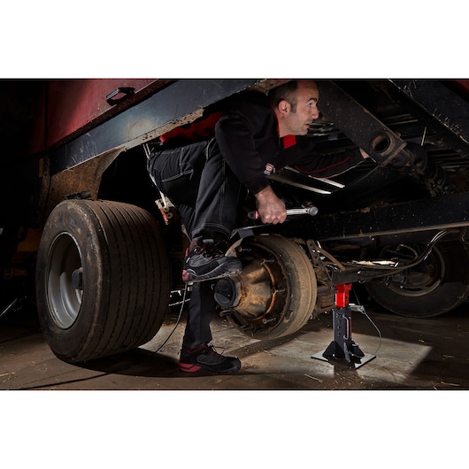 Facom DLPL22A photography of mechanic working on truck axle with jack stand and tire removed.