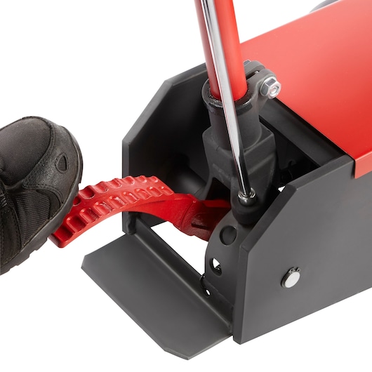 Facom DLPL5 hydraulic jack close-up with black shoe pressing red foot pedal, side angle on white background.