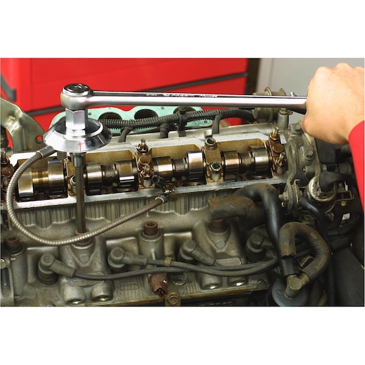 Facom DMP_360L torque wrench used on engine valve system, close-up photography of automotive maintenance.