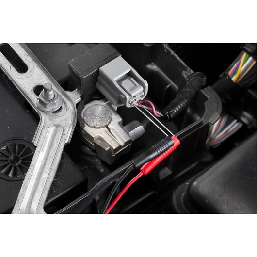 Facom DX_SET automotive electrical connector with multimeter test leads attached, close-up detail.