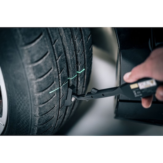 Facom DX_TSCANPB automotive tire scanner measuring tread depth with green laser guided lines.