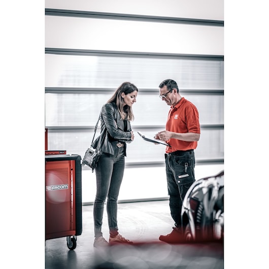 Photo of Facom DX_TSCANPB tool cabinet in a workshop with two people talking, one holding a clipboard.