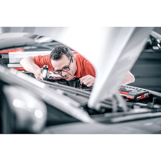 Facom DX_TSCANPB mechanic using inspection lamp in car engine bay, automotive tool photography.