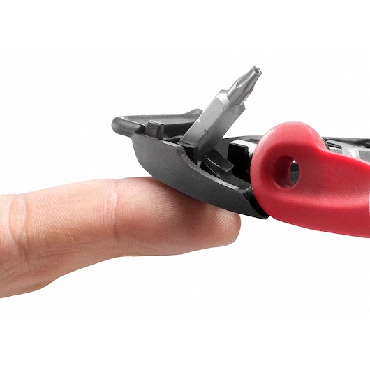 Facom E110 screwdriver with red handle and interchangeable bit shown balanced on a finger, close-up, white background.