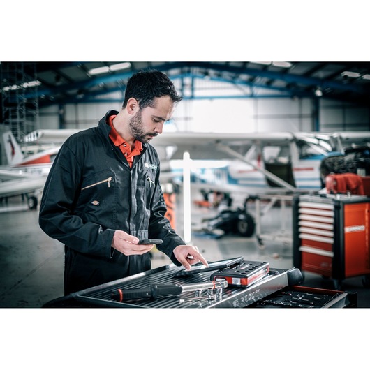 Facom E_516ST-135PB mechanic in workshop using tool tray in front of aircraft and tool chest.