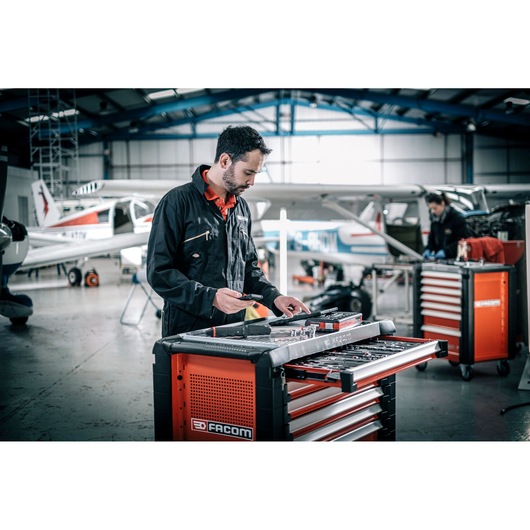 Photo of Facom E_516ST-135PB tool chest in a hangar with an aircraft mechanic organizing tools.