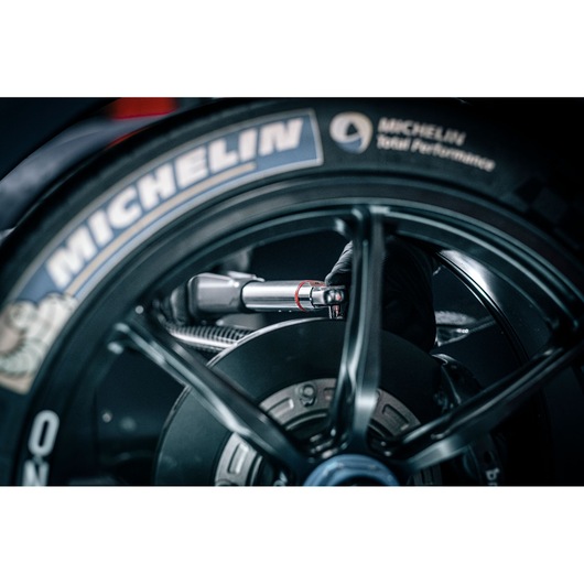 Facom E_516ST-135PB torque wrench used on a motorcycle wheel, close-up showing detailed tool application.