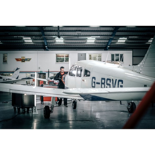 Facom E_516ST-135PB photography of a white aircraft in a hangar with technician working near the engine