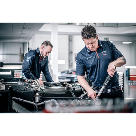 Photo of two technicians using a Facom torque wrench E_516ST-30PB in a workshop, working on machinery.