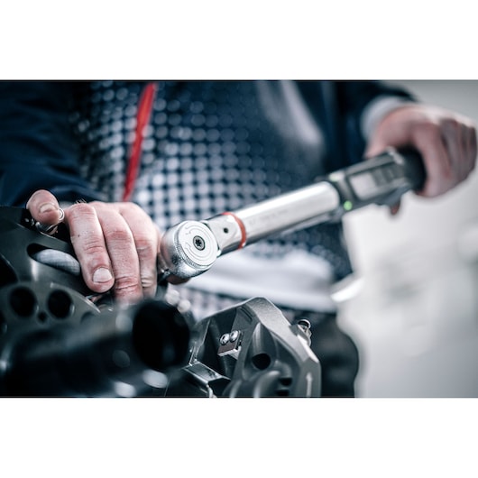 Facom torque wrench E_516ST-340PB in use, close-up of hands adjusting mechanical part.